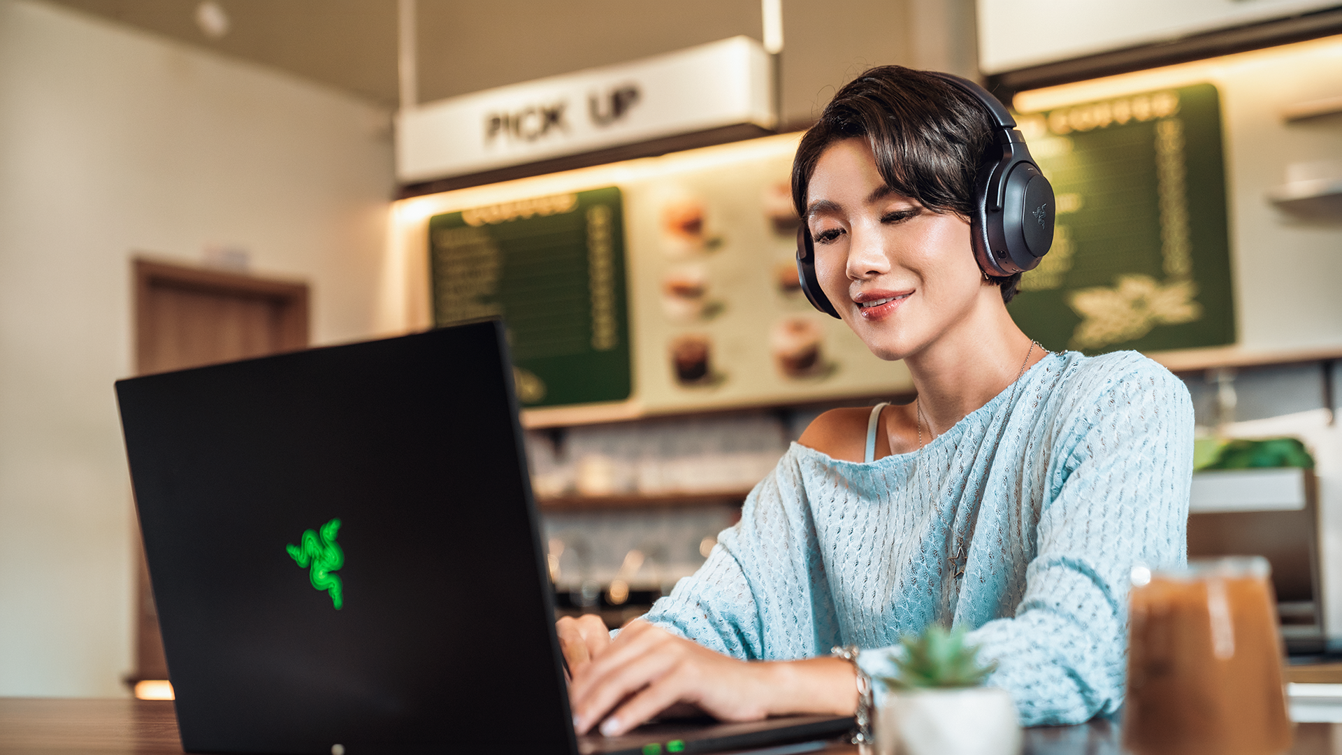 Utilizarea căștilor Barracuda V2 Pro alături de un laptop, într-o cafenea
